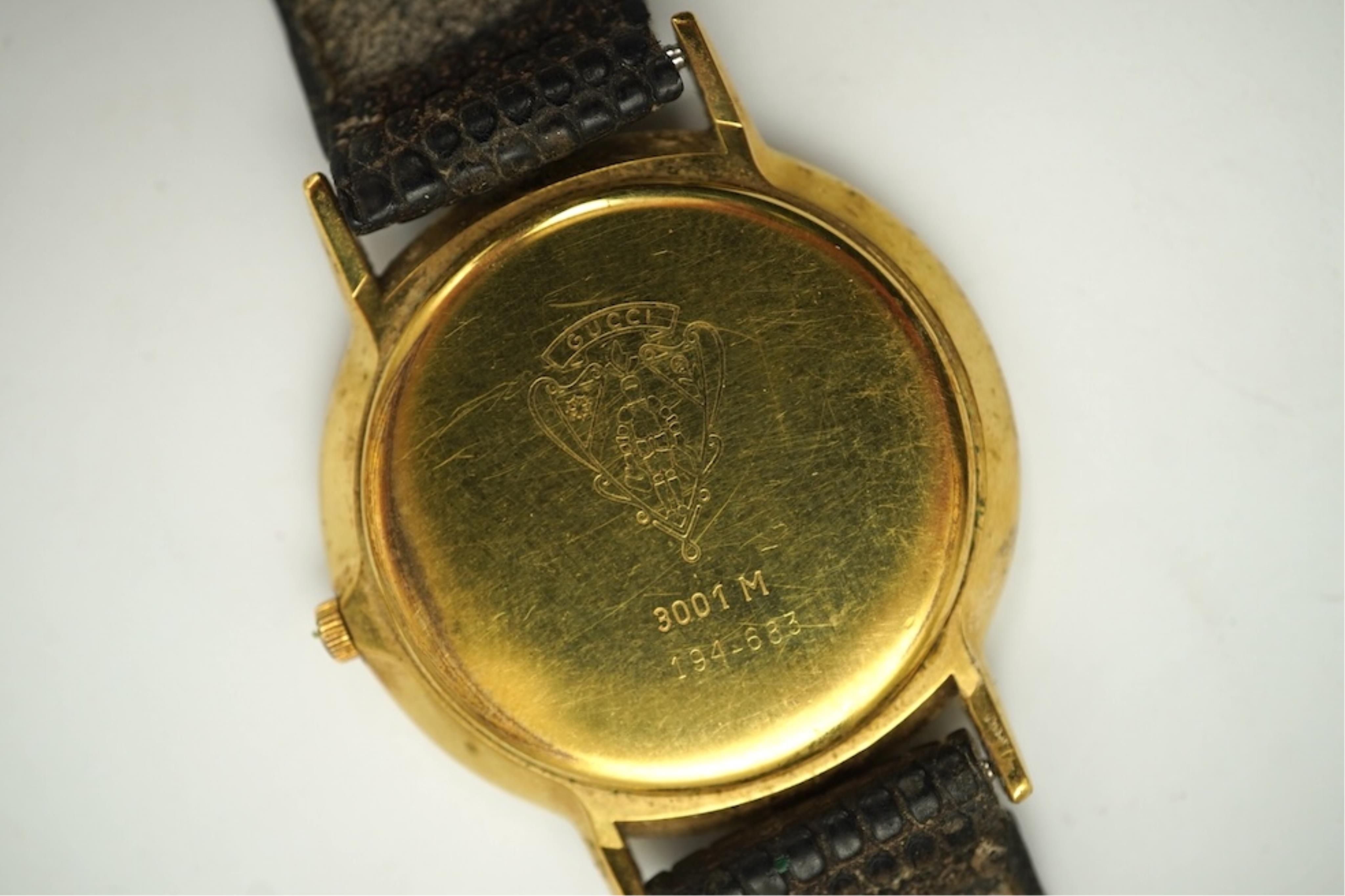 A gentleman's recent 18k gold electro-plated Raymond Weil quartz dress wrist watch, case diameter 33mm and a similar Gucci quartz dress wrist watch.